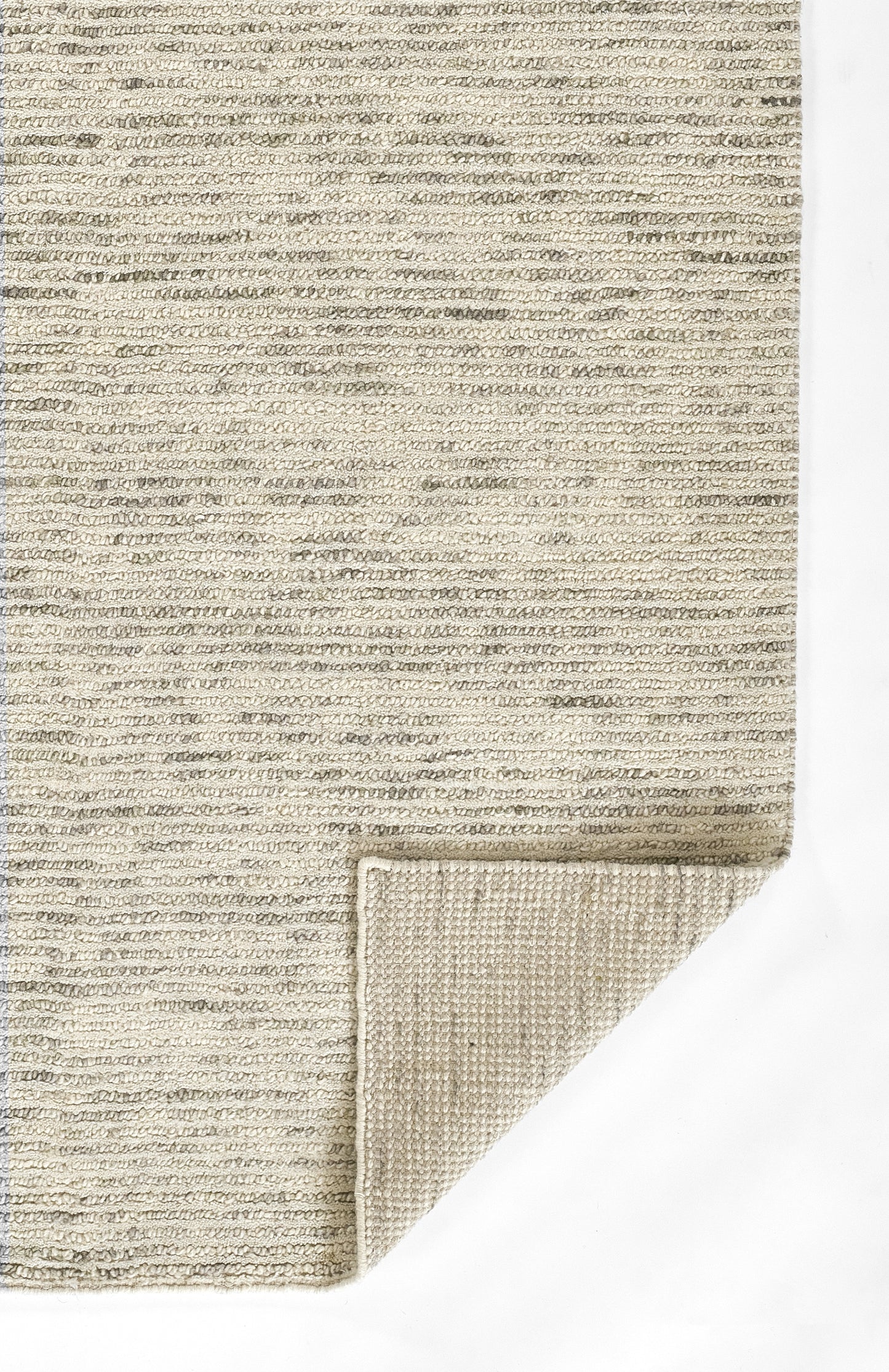 Beige textured rug with looped pile; folded corner shows lighter underside, neutral cream tones.