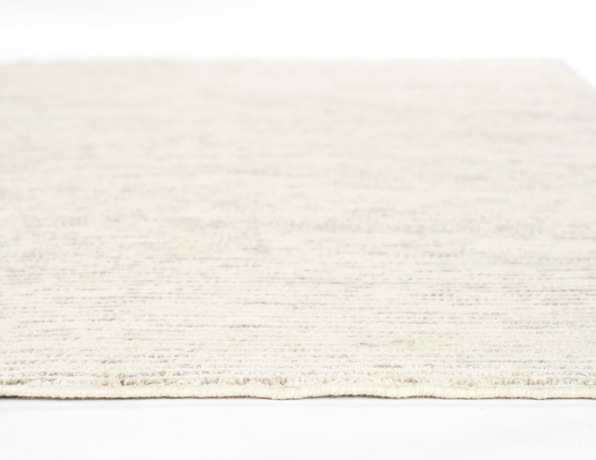 Cream beige rectangular area rug with subtle textured pattern and short fringe along edge.