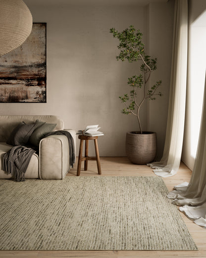 Beige sofa with gray cushions, light textured runner rug, wooden stool with open book, tall potted tree, cream curtains.