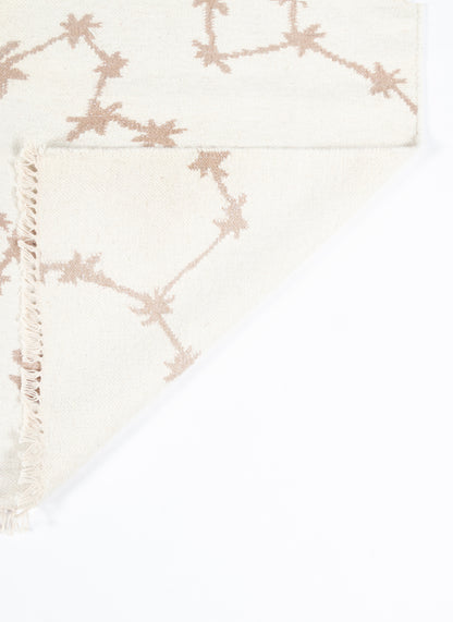 Ivory woven rug/throw with pink-beige star-shaped geometric motif and fringed edge.