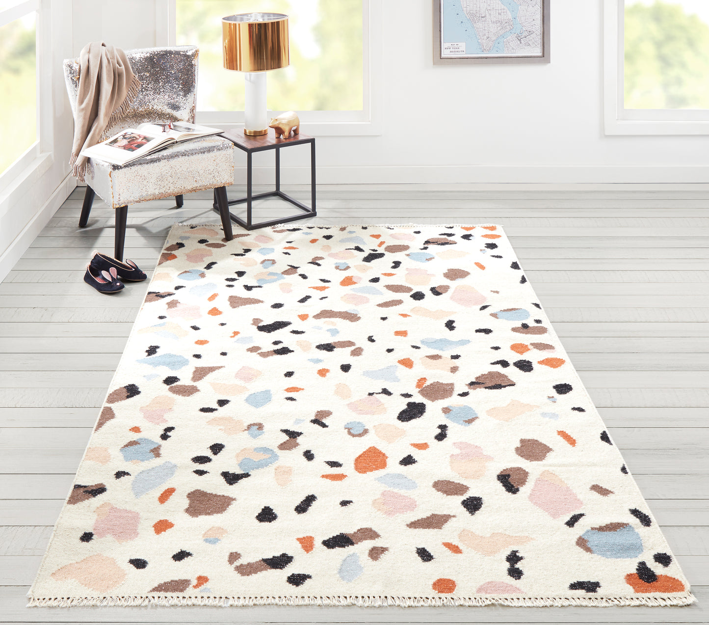 Rectangular cream runner with multicolor terrazzo-style spots in peach, blue, gray and black, with fringed edges.