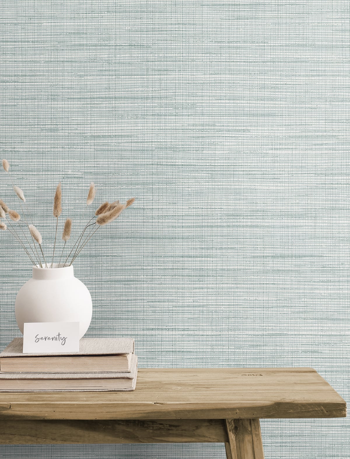 Blue rustic matte stringcloth textile on a wooden table with stacked books and a serenity card against a blue textured wall.