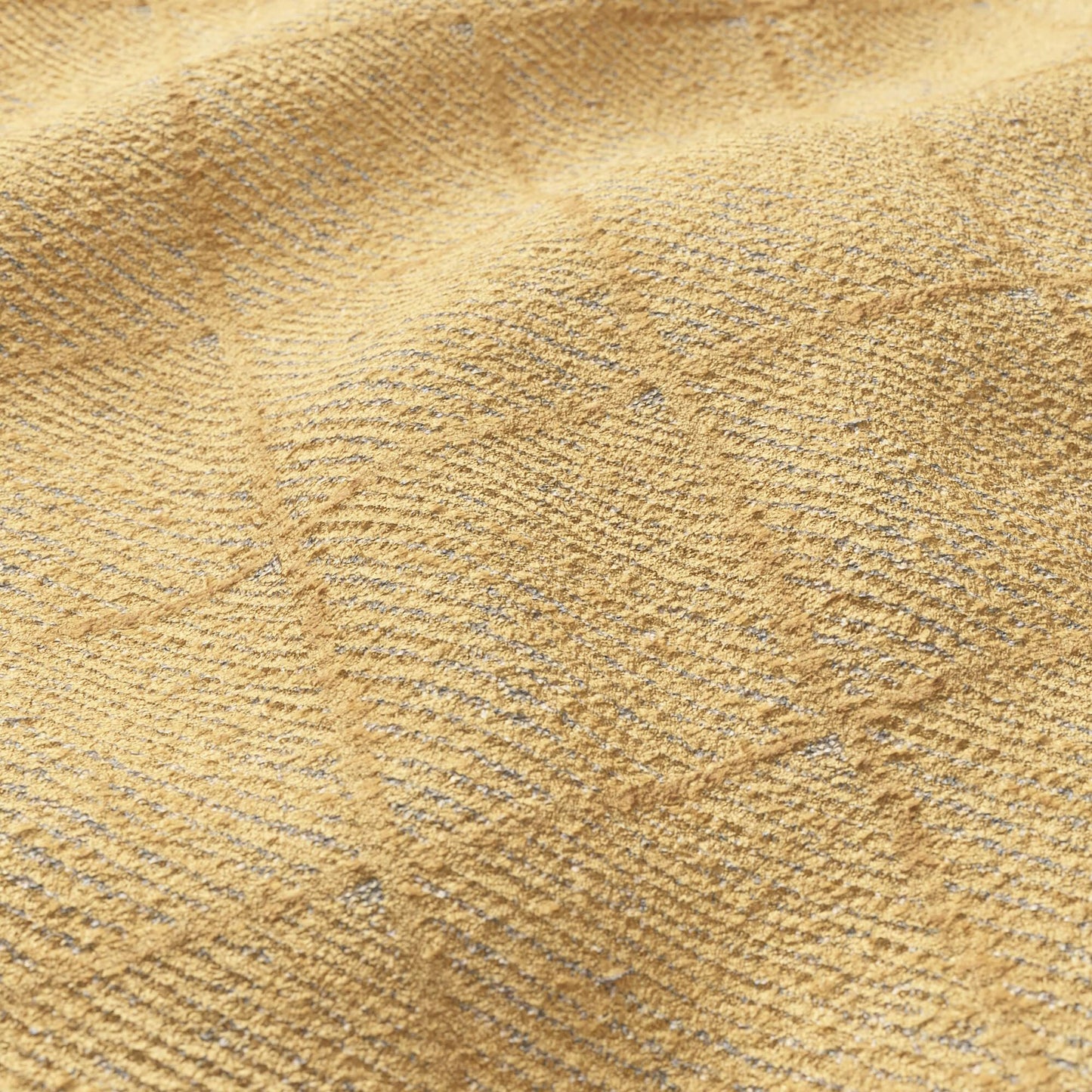 Close-up of warm sand-colored velvet fabric with subtle pile and heather specks.