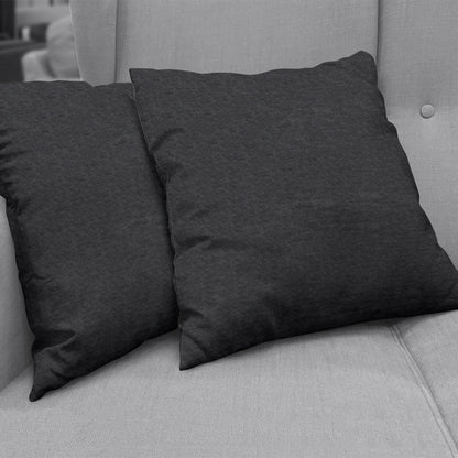 Charcoal gray ebony solid textured upholstery fabric on a light gray sofa with square throw pillows, cozy living room decor.