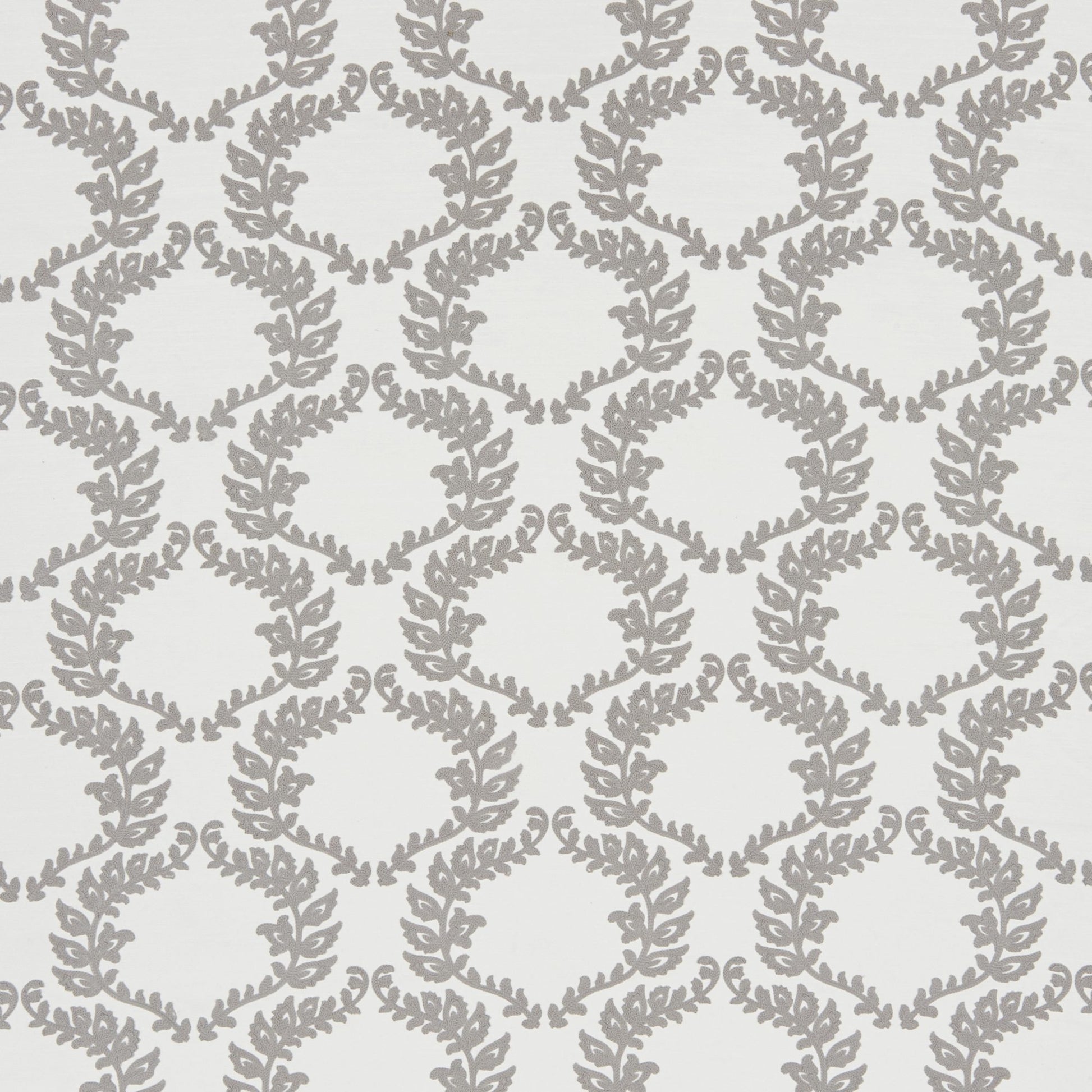 Grey leafy vine trellis pattern on pale background; embroidered floral fabric.