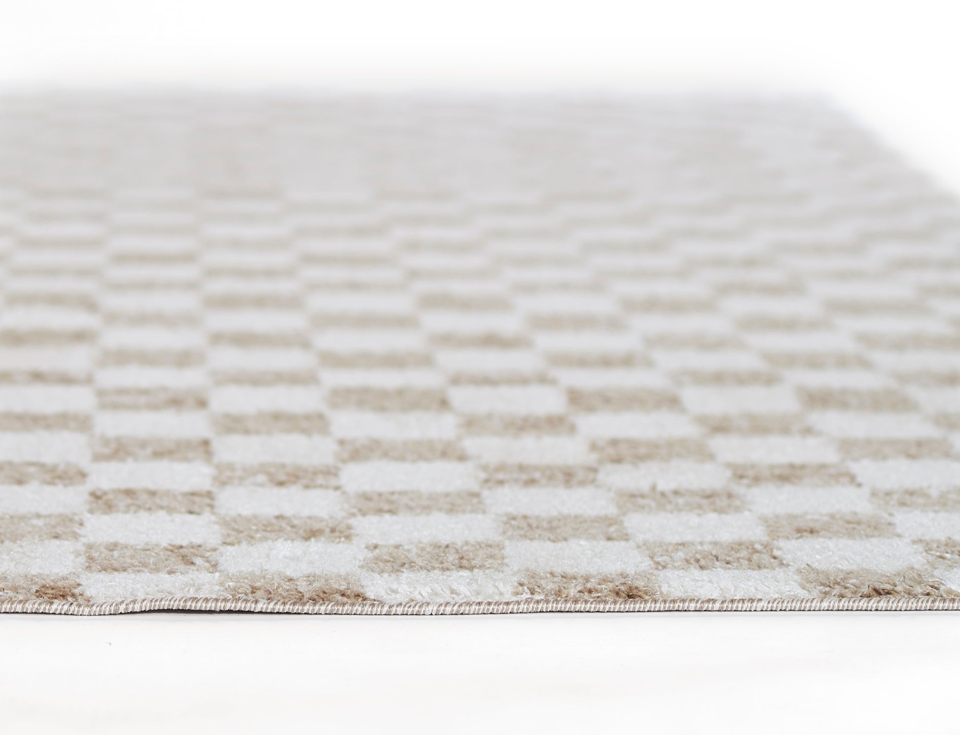 Beige checkerboard rug with soft woven texture in neutral cream and taupe tones, perspective view.