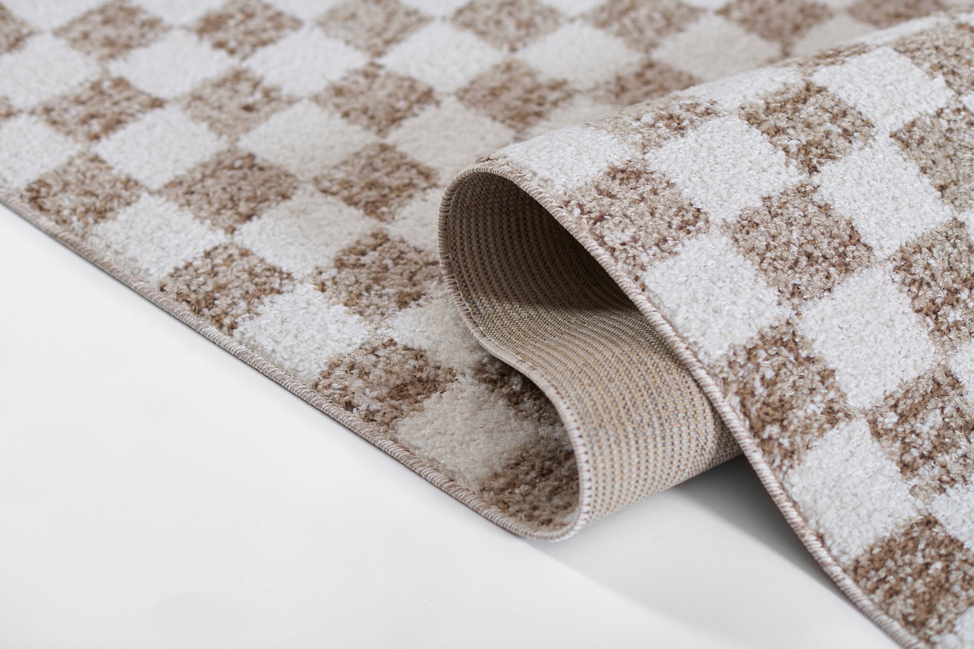 Beige and brown checkered rug with plush pile, rolled edge showing woven underside, cozy home decor.