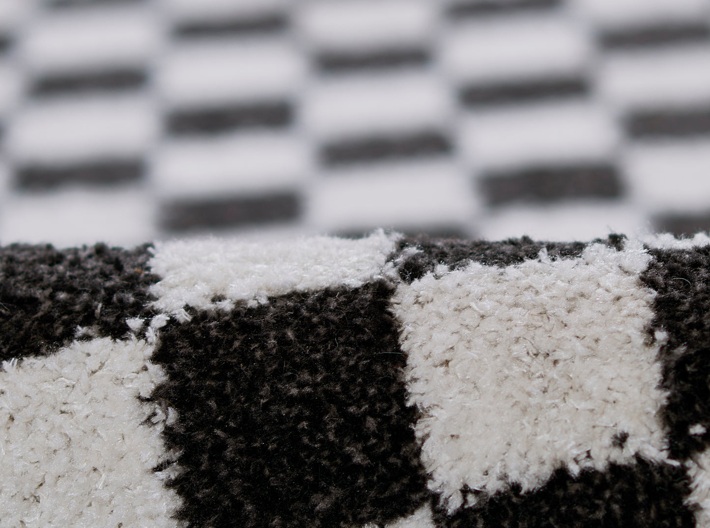 Close-up of black and white checkerboard rug with a soft, fluffy texture.