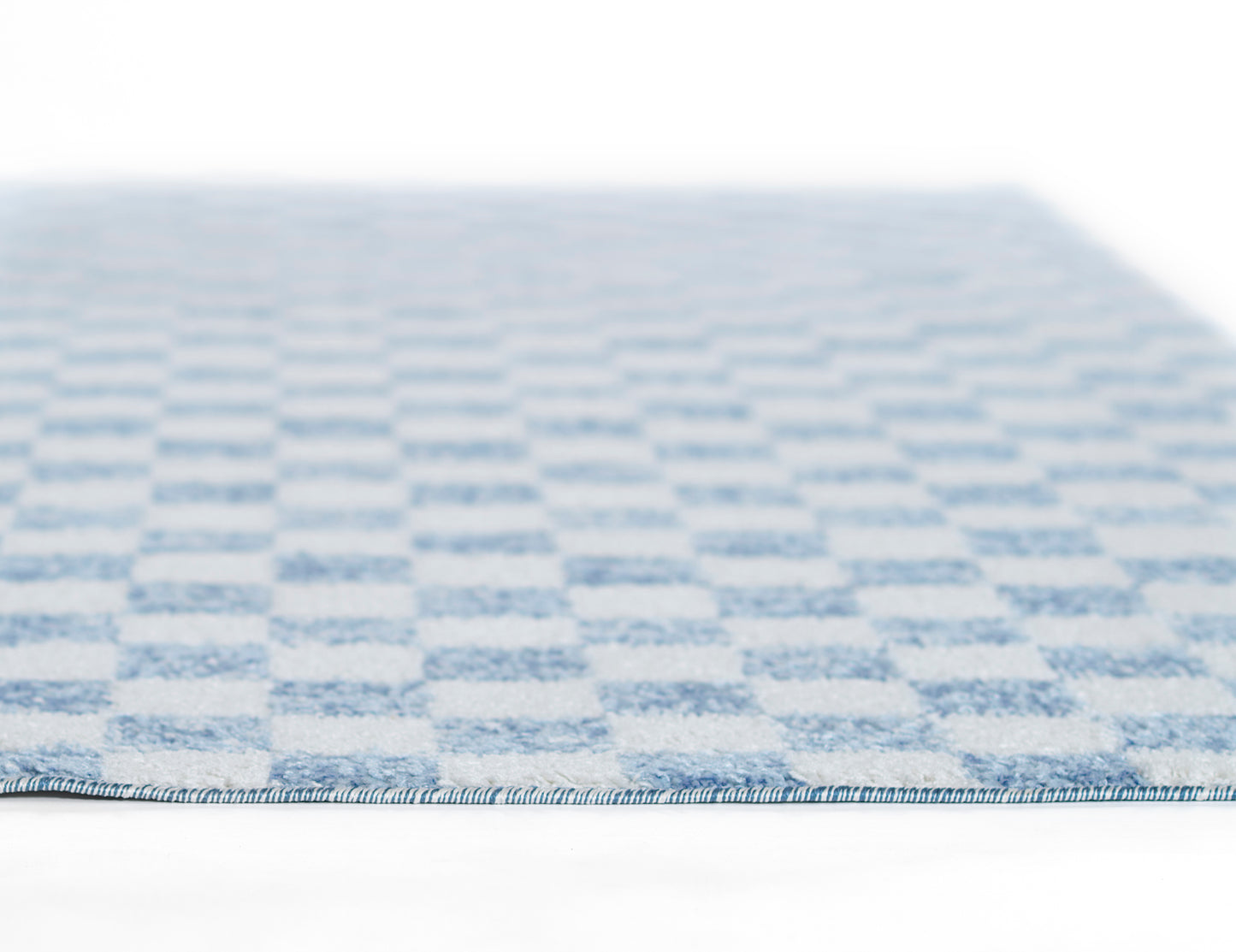 Blue and white checkered flat-weave rug with a blue edge binding, low-profile textile.
