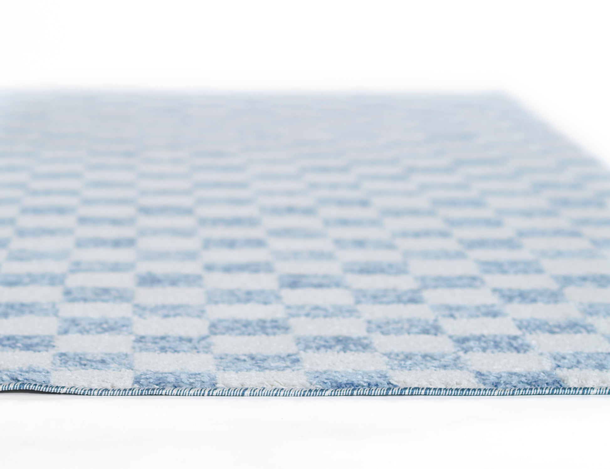Blue and white checkered flat-weave rug with a blue edge binding, low-profile textile.