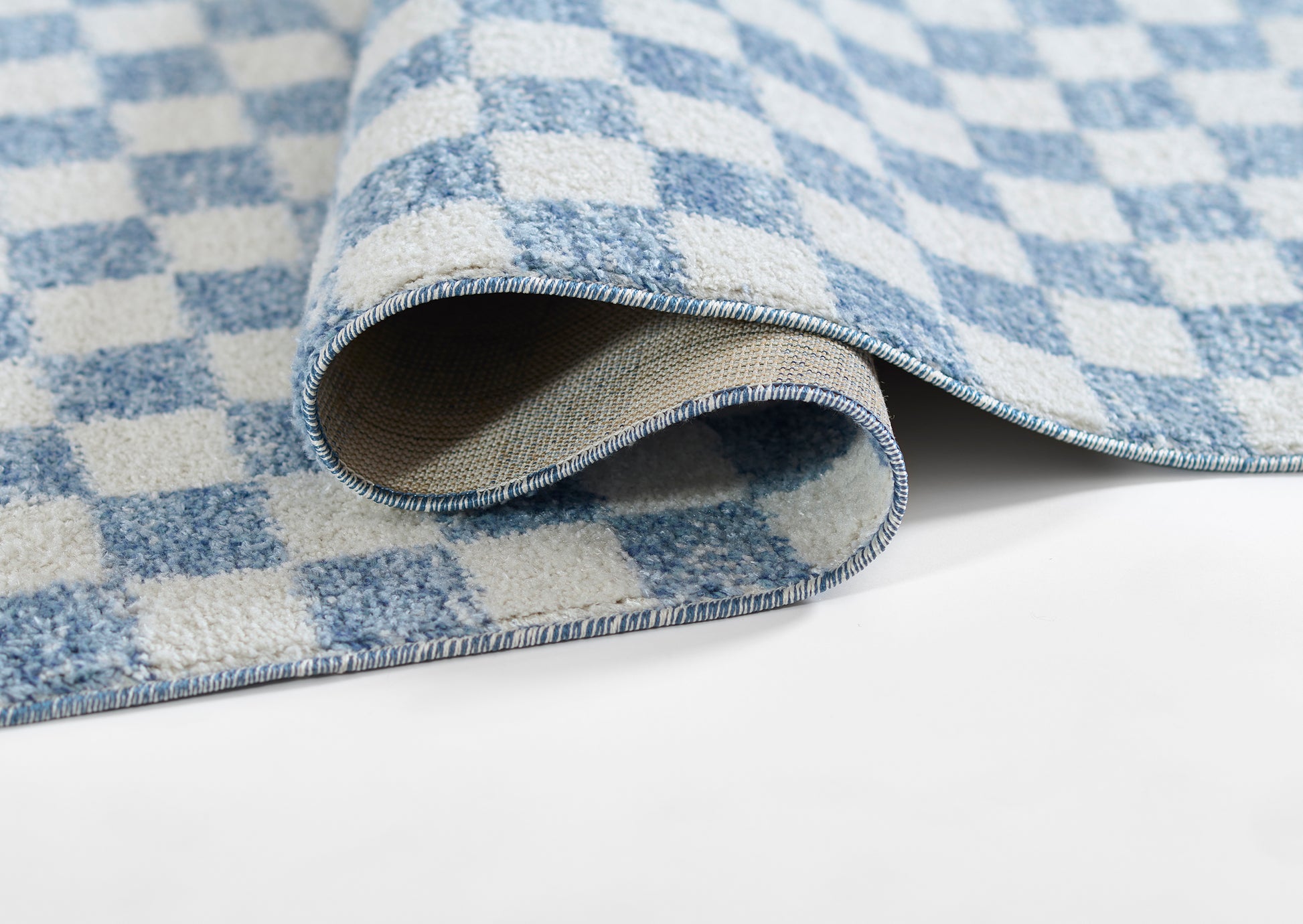 Blue and white checkered rug with soft woven texture and rolled edge.