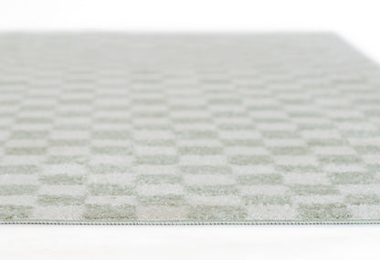 Close-up of a pale green and ivory checkered rug with soft woven texture and slim edge binding.