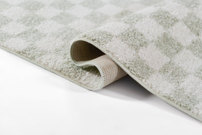 Soft grey-green geometric checkered rug with plush pile and exposed underside.