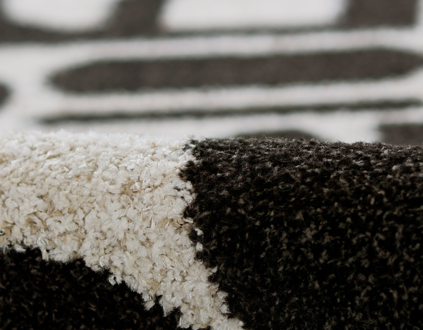 Close-up of black & white zebra-pattern shag rug with plush, high-pile texture.