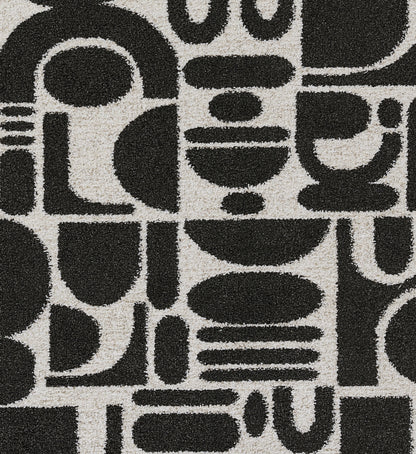 KAIA black geometric patterned rug with bold abstract shapes on ivory background.