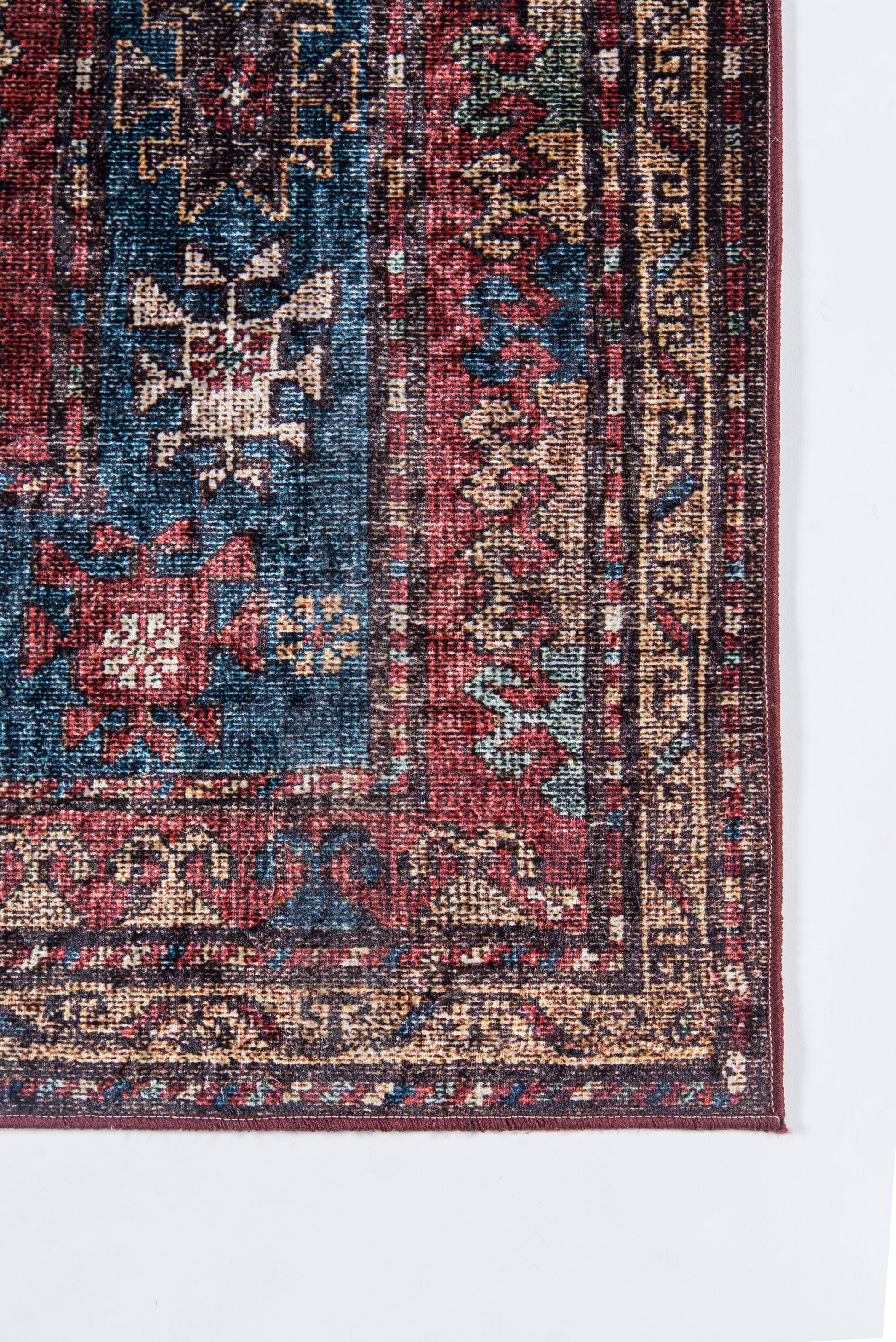 Partial view of a traditional Persian-style rug with red and blue field, teal accents, and beige/gold ornate border patterns.