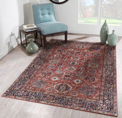 Red and navy Persian-style area rug with intricate pattern on light wood floor, beside a teal chair and green ceramic vases.
