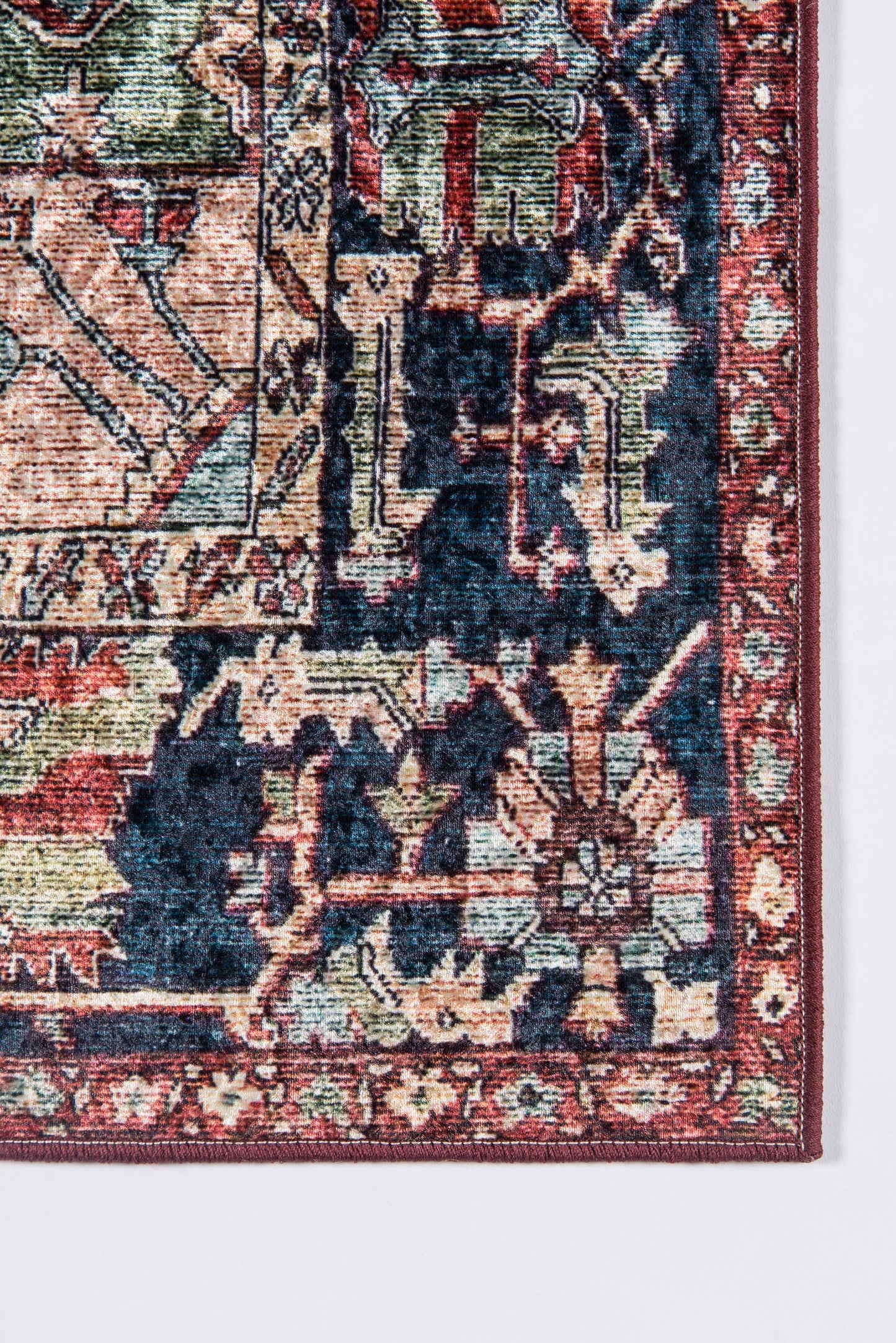 Oriental rug corner: navy field with red border, cream and peach floral-geometric motifs; woven texture.