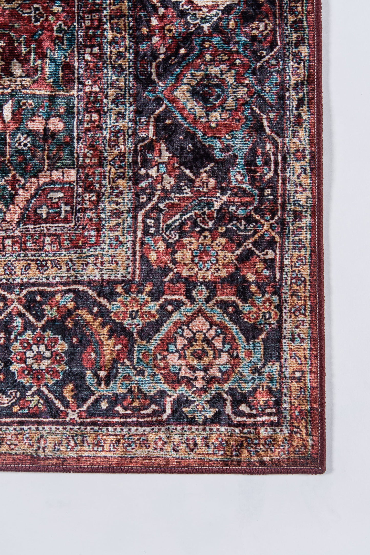 Persian-style oriental rug corner with red, navy, teal floral motifs and ornate borders.