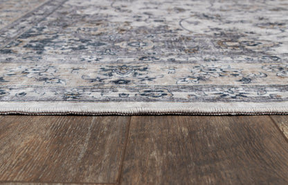 Gray-blue patterned area rug with beige accents and floral medallion design on dark wooden floor.