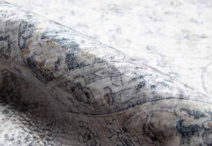 Gray-blue oriental rug close-up with floral border pattern and woven texture