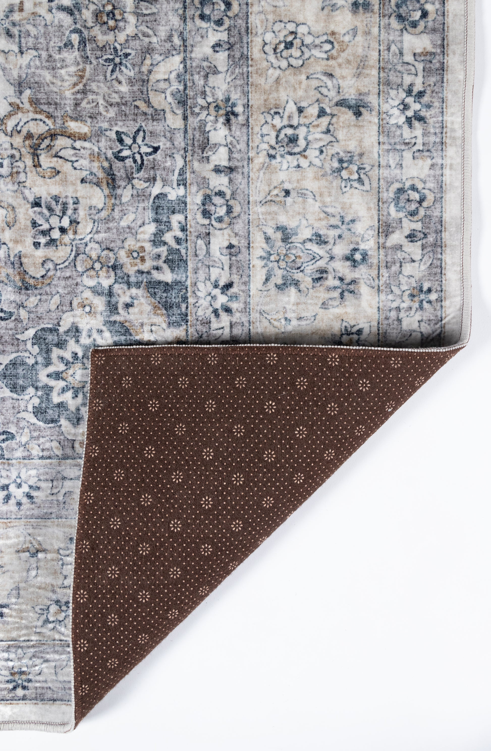 Rectangular vintage gray-blue floral area rug with bordered pattern; brown underside with small dot print.