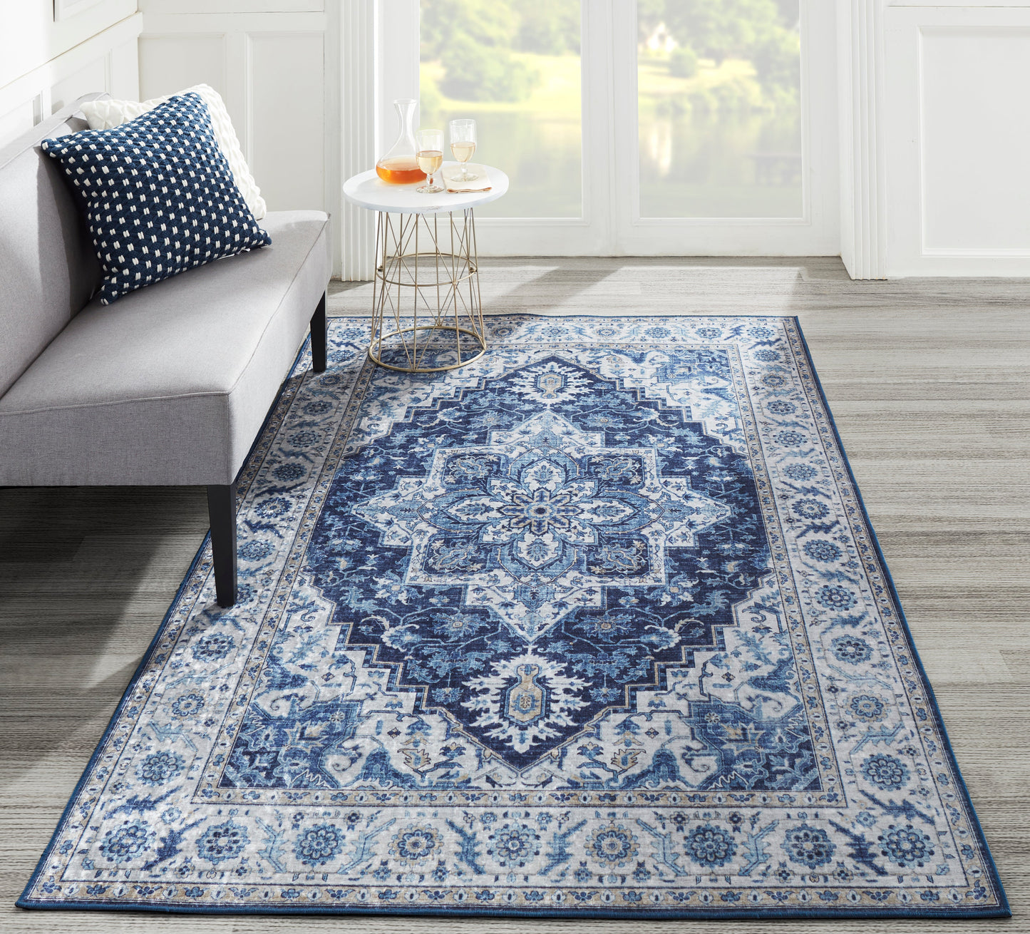 Blue woven Persian-style runner rug with intricate medallions and border, in a bright living room with a gray sofa.