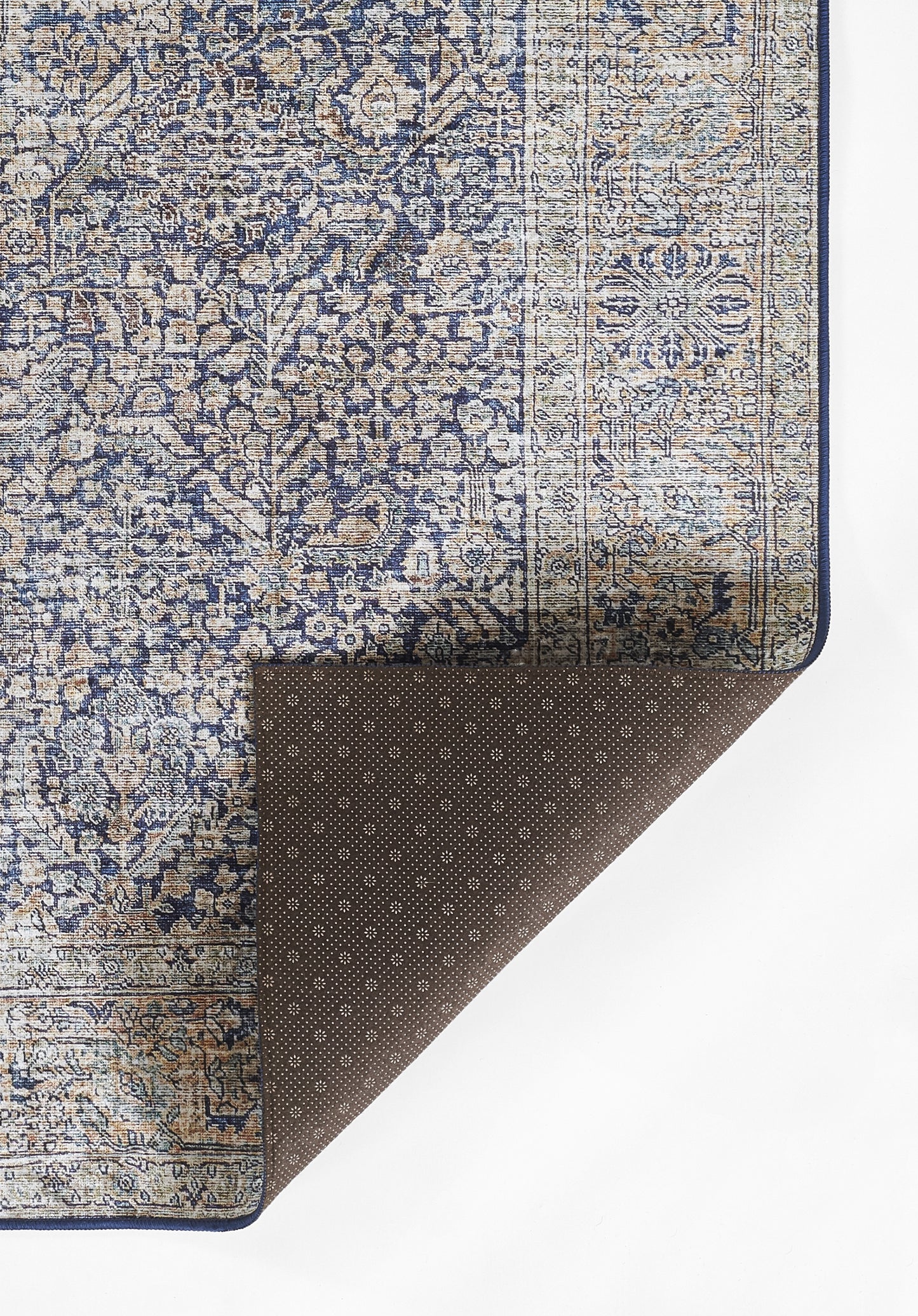 Blue & beige oriental rug with floral pattern & border; brown dotted underside folded at corner.
