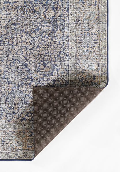 Blue & beige oriental rug with floral pattern & border; brown dotted underside folded at corner.