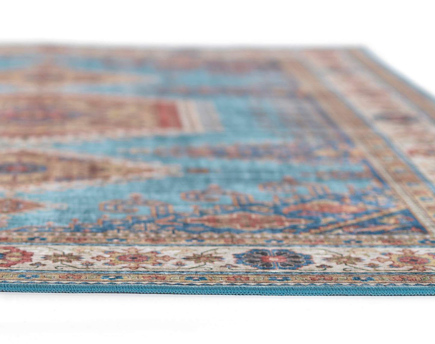 Blue oriental-style area rug with cream border, intricate floral motifs and distressed weave.