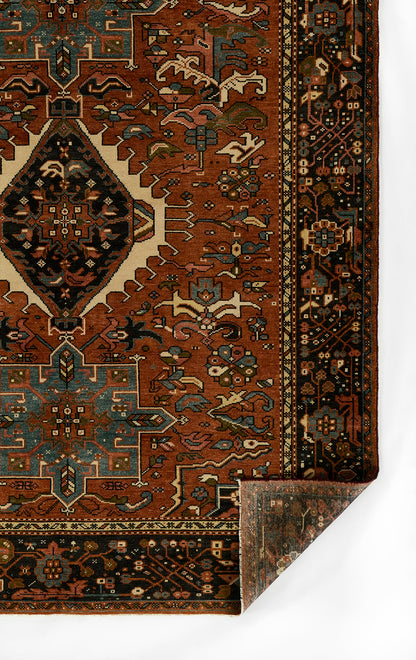 Red oriental rug with teal, ivory and navy geometric motifs, central diamond medallion and dark border; rectangular rug.