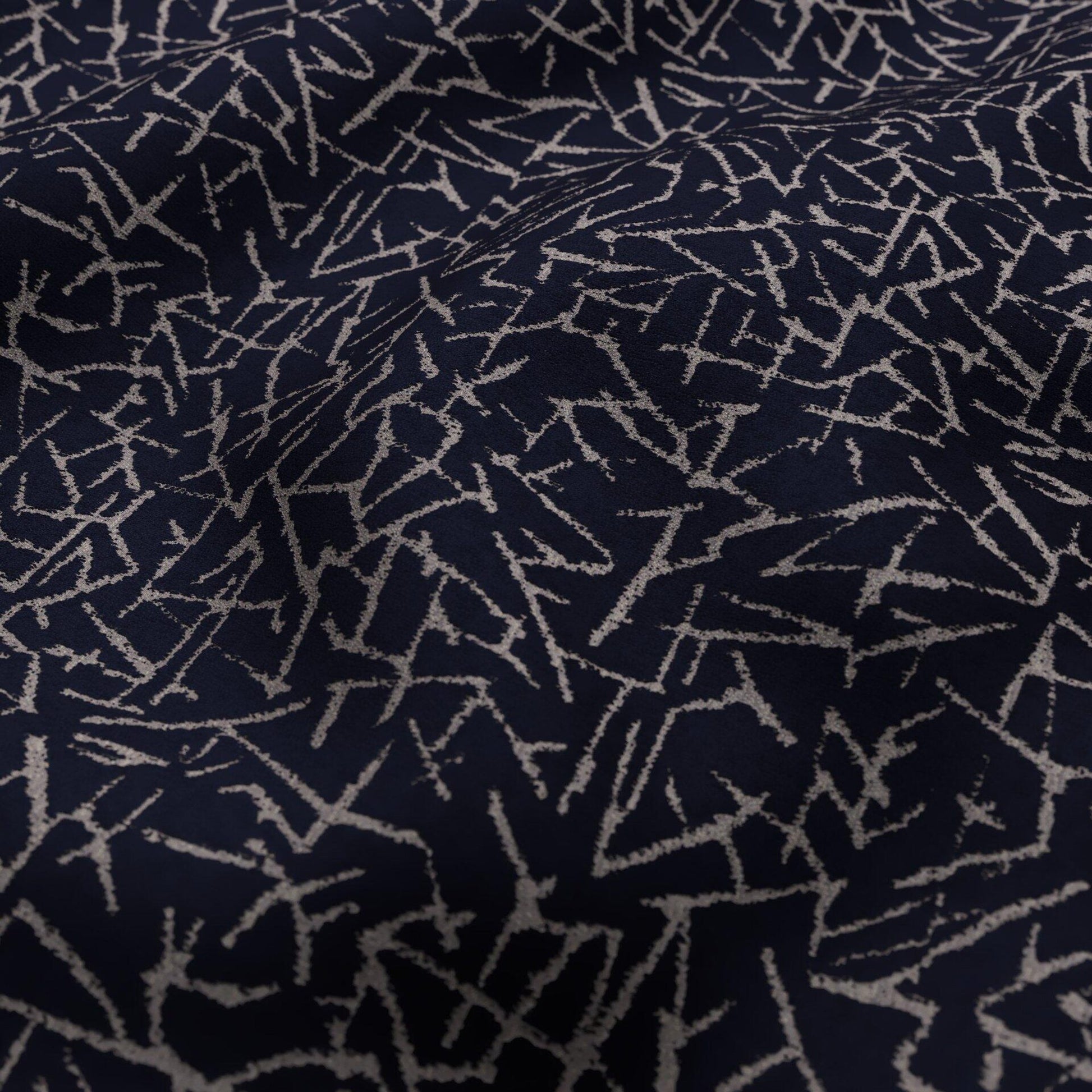 Navy blue fabric with silver scattered zigzag lines; abstract textile for upholstery or throw.