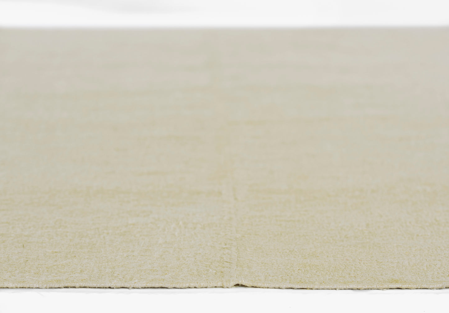 Beige flat-weave rug close-up with soft texture & light, even color; ideal for living spaces.