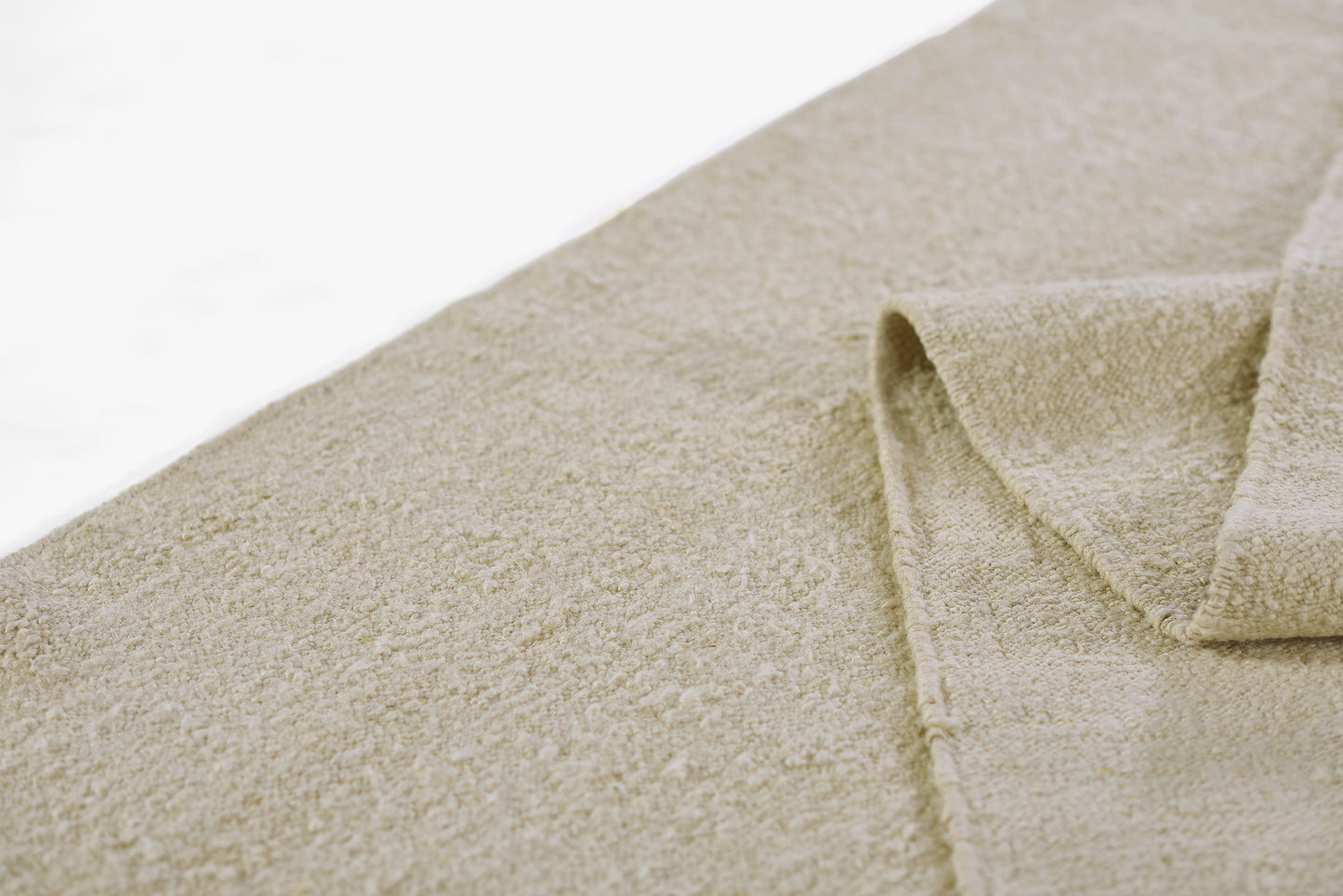 Beige terry cotton towel with plush loop texture, folded corner, ideal for bath or spa use.
