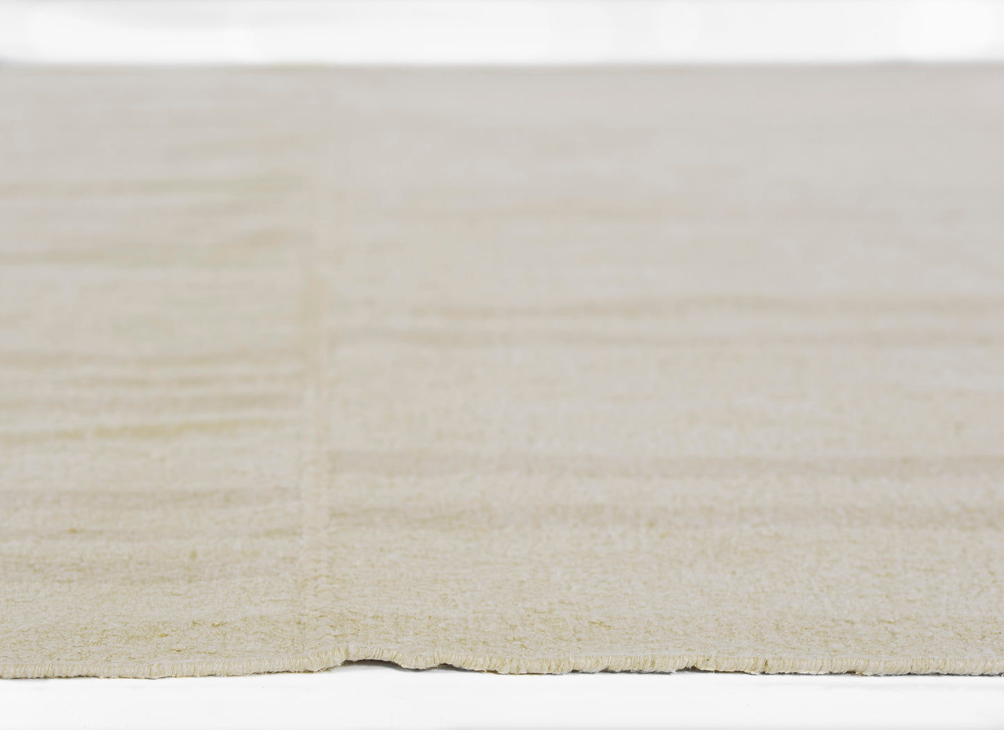 Beige textured rug with a subtle linear pattern and soft low-pile feel.