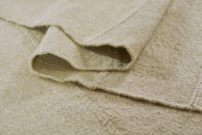 Beige patchwork rug with plush looped pile and rolled edge, 10' x 14'.