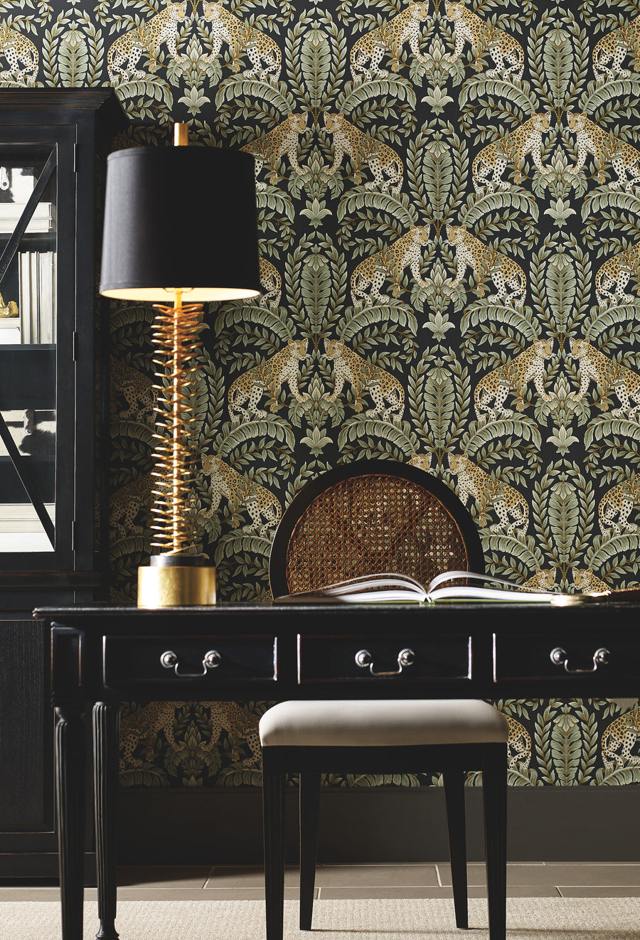 Luxury leopard and botanical wallpaper featuring tan spotted leopards against a deep black background, framed by sage green foliage, acanthus leaves, cream flowers, and gold-brown details.