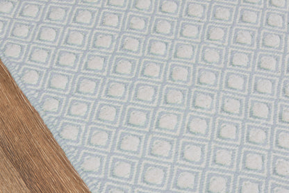 Blue woven rug with white square-grid pattern; geometric, textured motif on wooden floor.