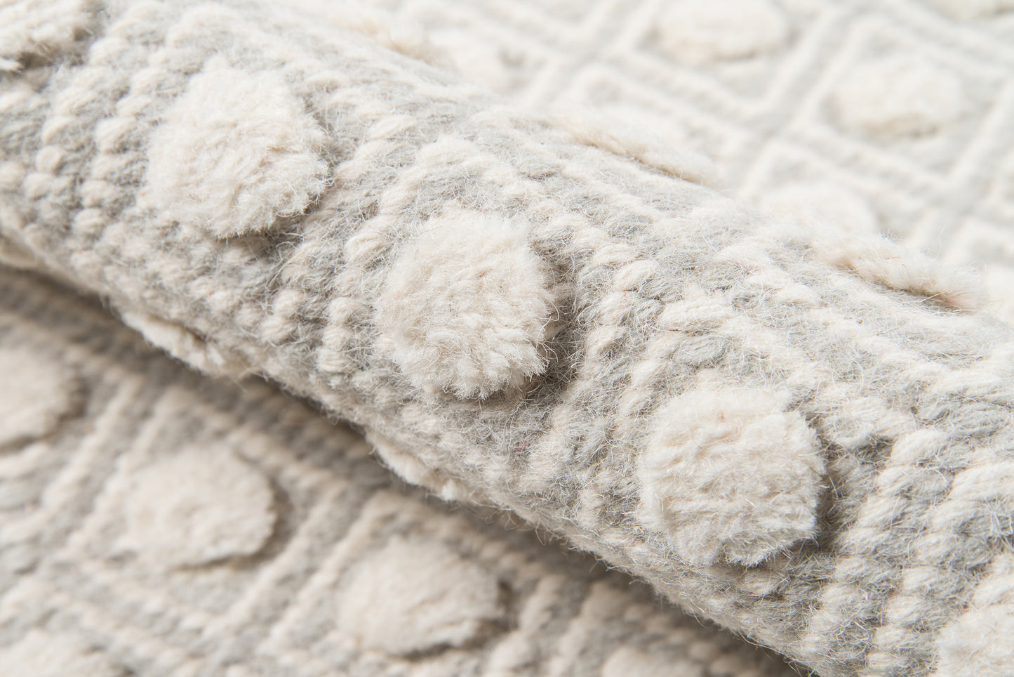 Soft grey and ivory tufted shag rug with raised circular dot motifs; plush wool texture, cozy boho style for home decor.