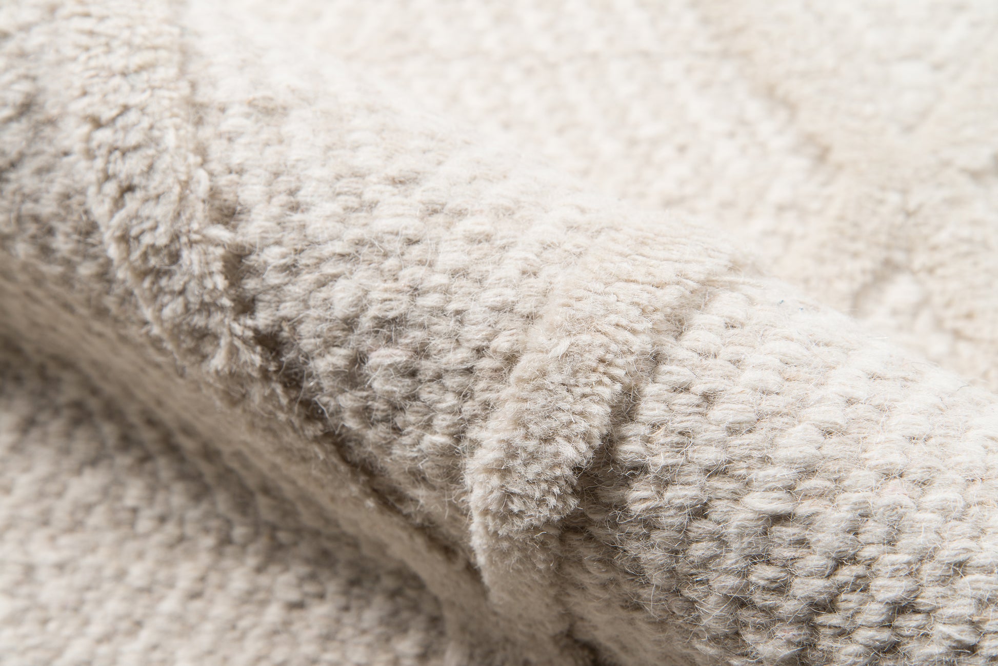 Beige textured rug with a soft looped pile; close-up of the rug surface (2' x 3').