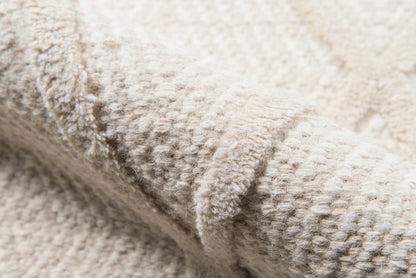 Beige textured loop-pile rug close-up with a soft, looped weave.