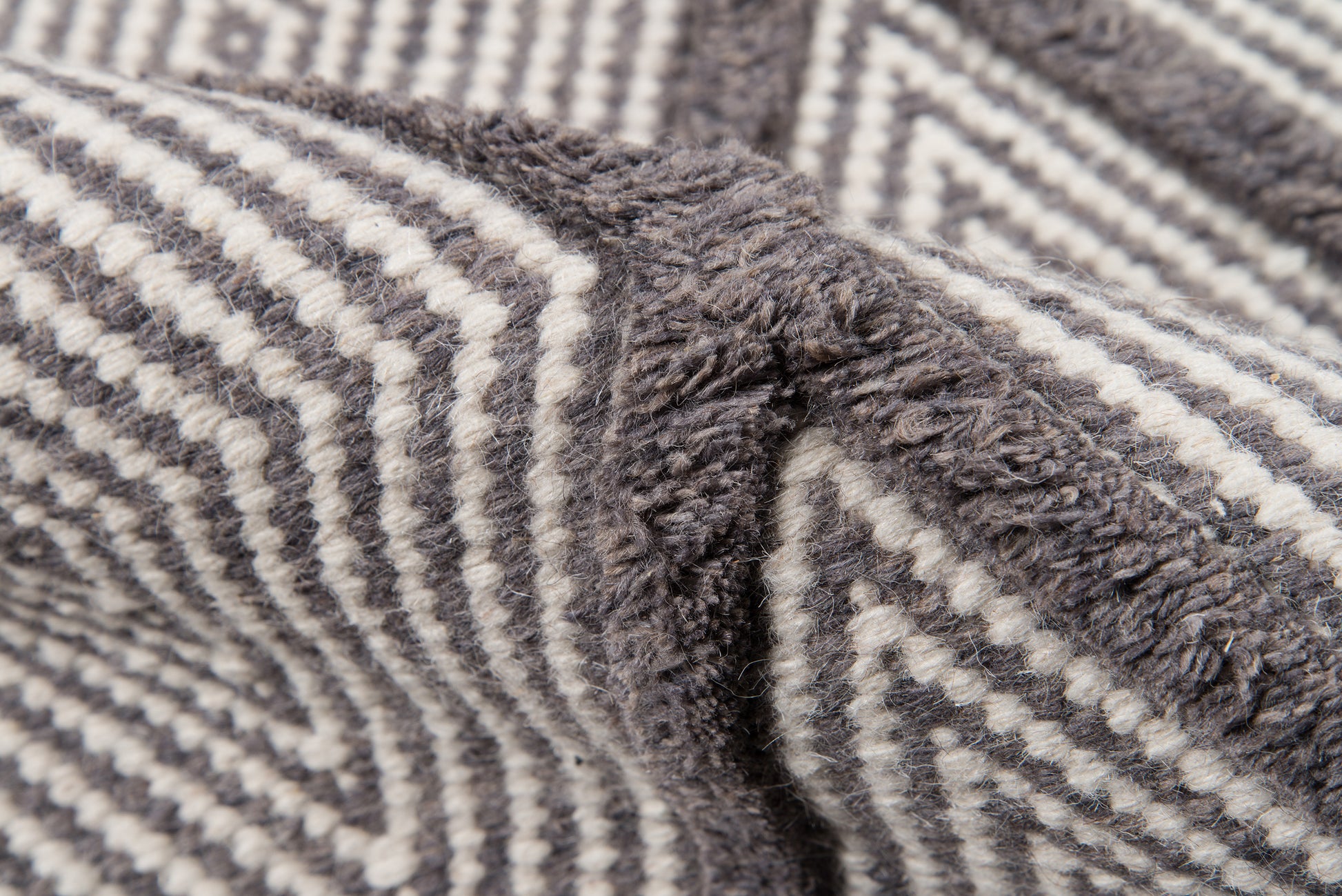 Soft plush grey and white striped chevron blanket, cozy throw for bed or couch.