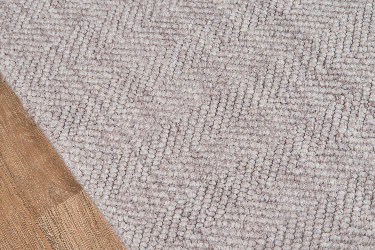 Light gray loop-pile area rug with subtle texture on wood flooring.