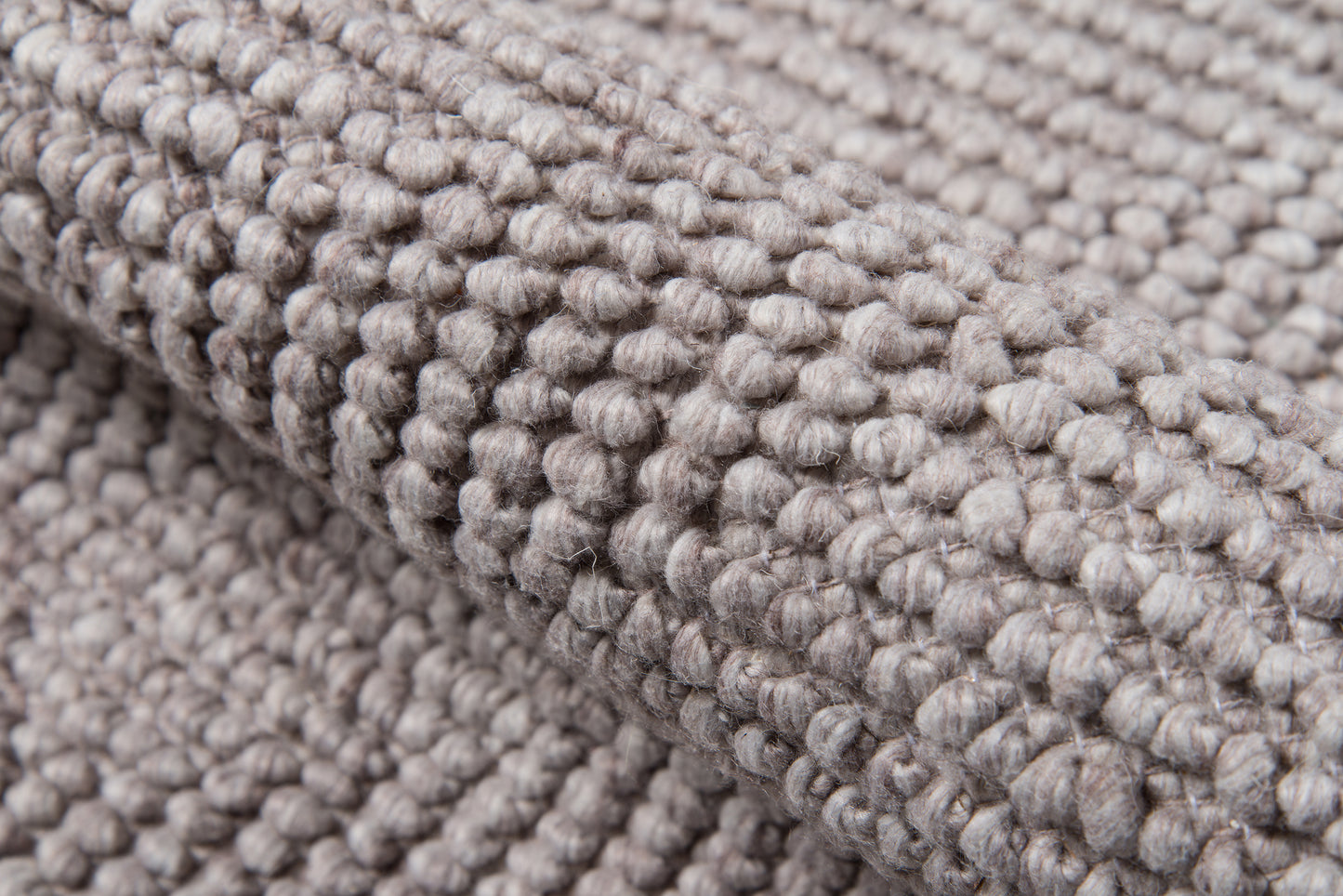 Taupe-gray bouclé rug close-up with chunky looped pile and soft woven texture.