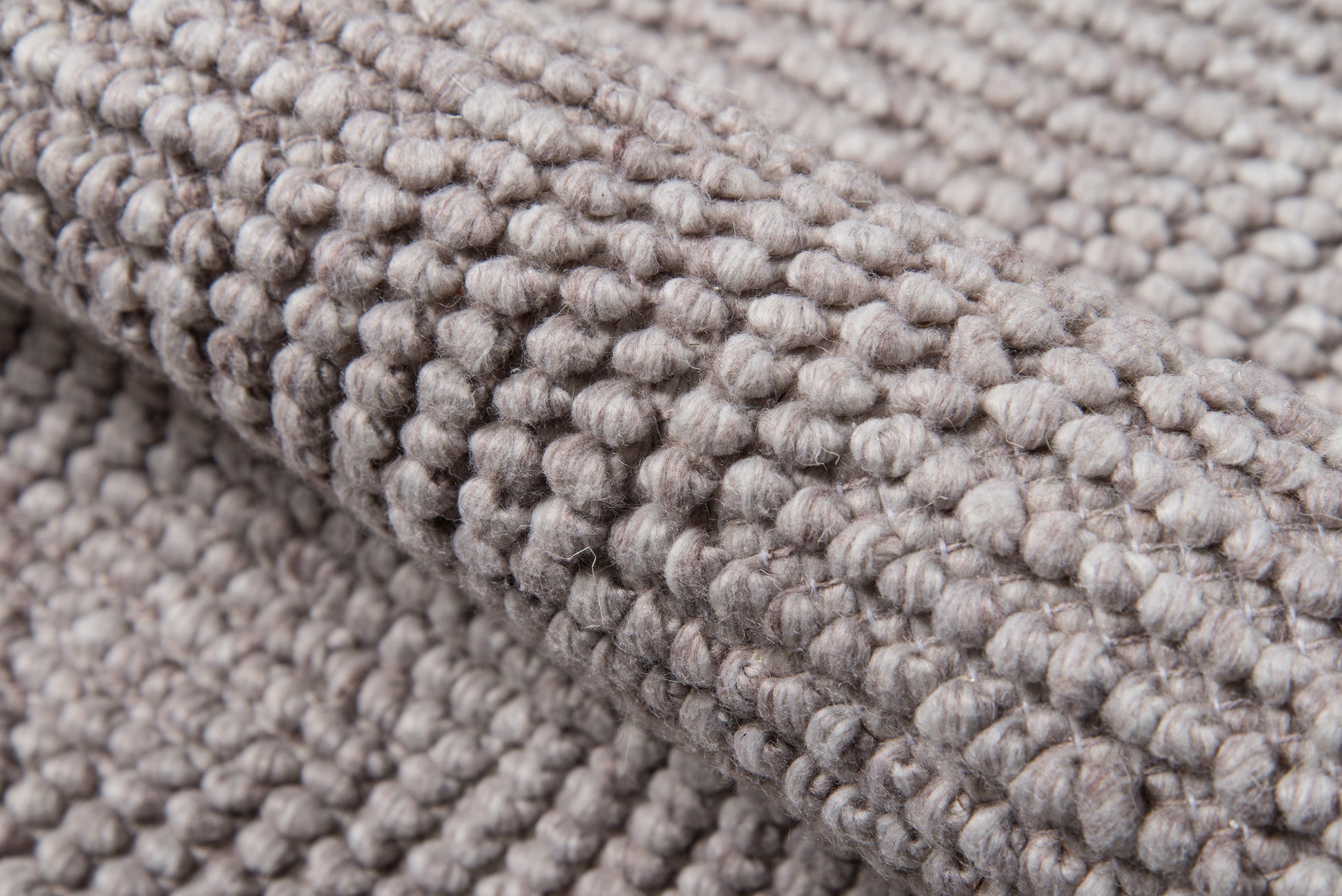 Taupe-gray bouclé rug close-up with chunky looped pile and soft woven texture.