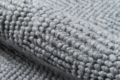 Close-up of soft gray loop-pile rug with dense plush texture.