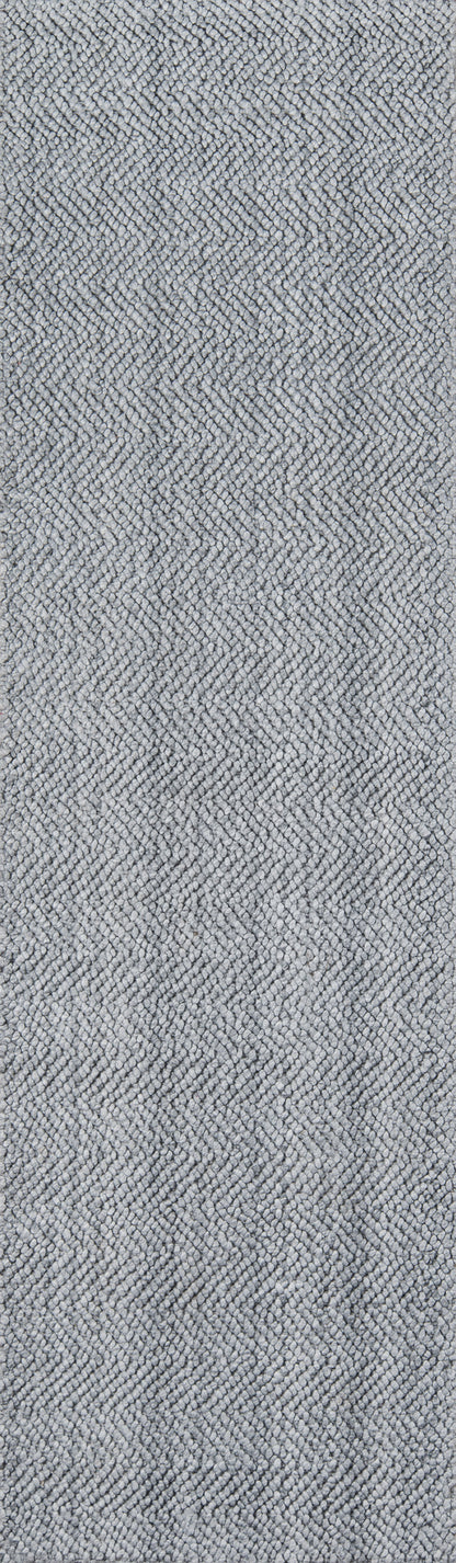 Gray herringbone woven rug texture with a subtle chevron pattern.