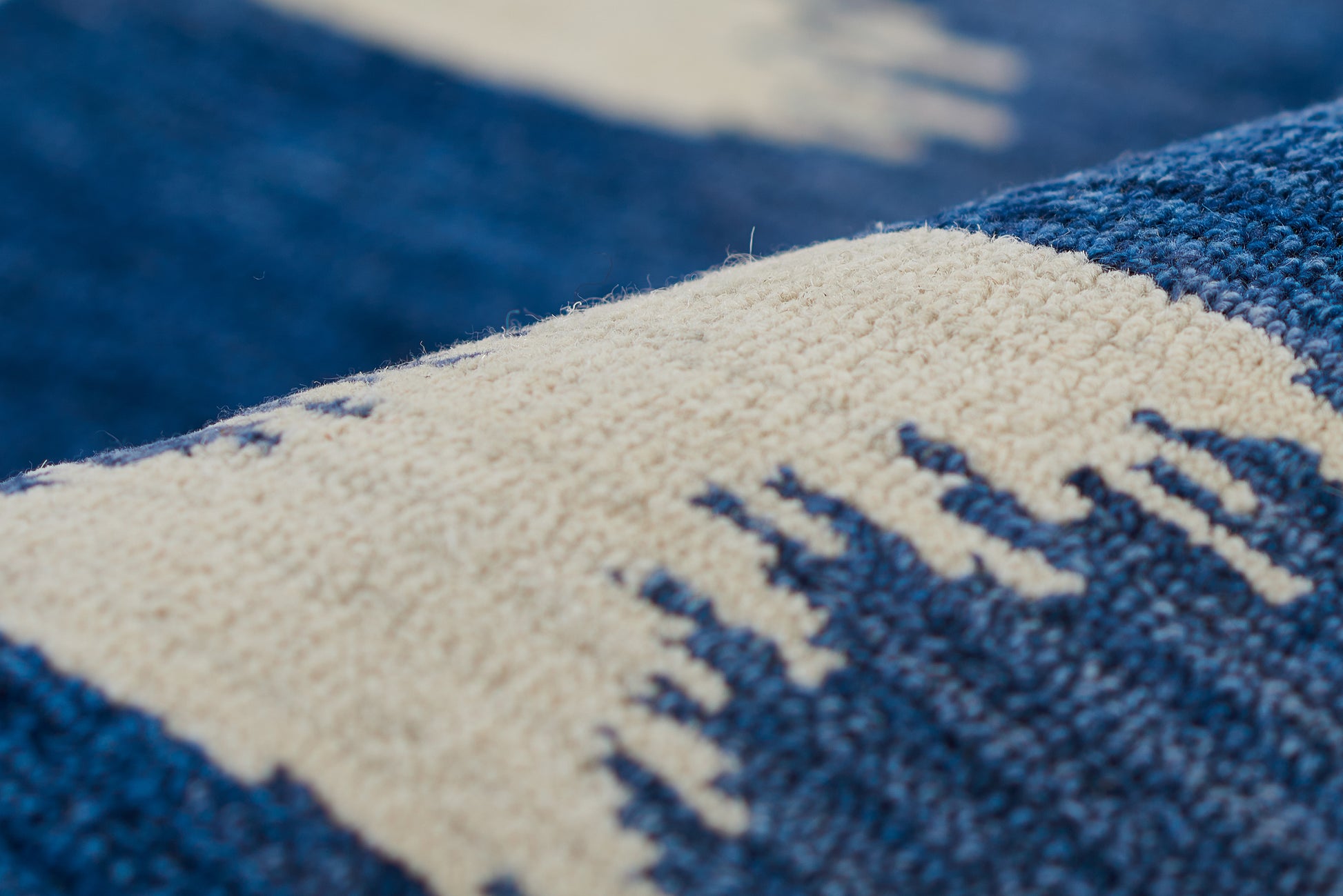 Close-up of blue and cream woven textile with geometric pattern and plush terry texture.