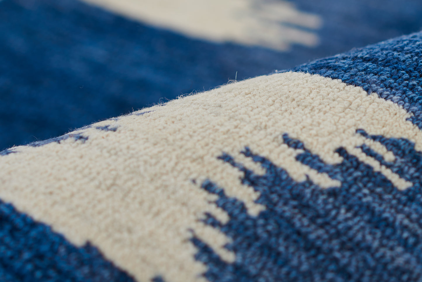 Close-up of a blue and ivory geometric stripe pattern on a rug.