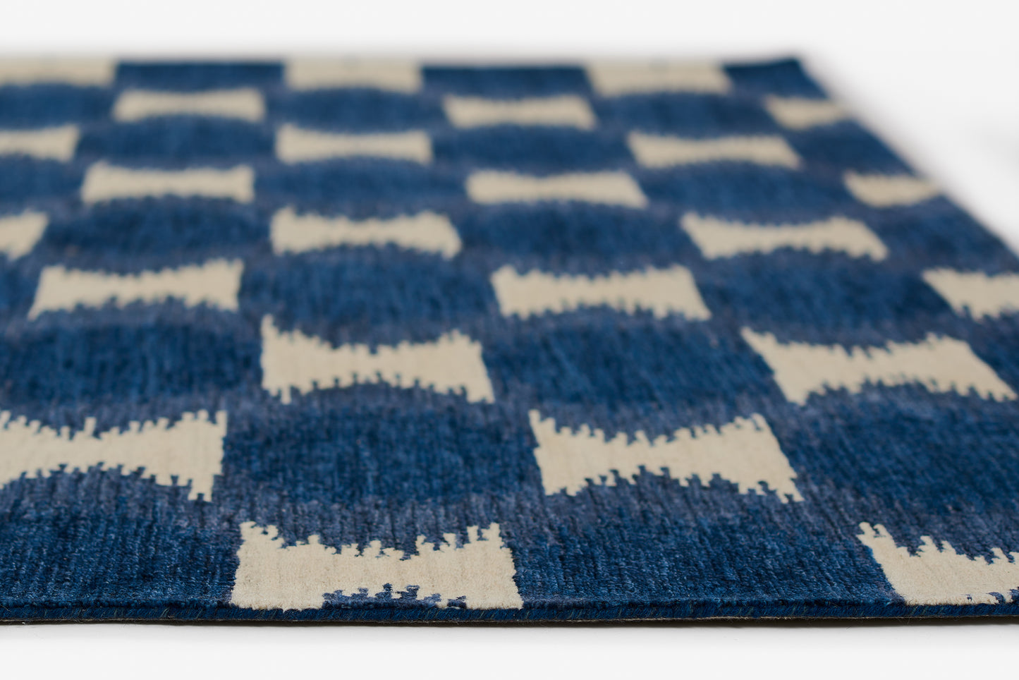 Blue and white geometric checkered rug with a textured woven surface, rectangular modern decor.